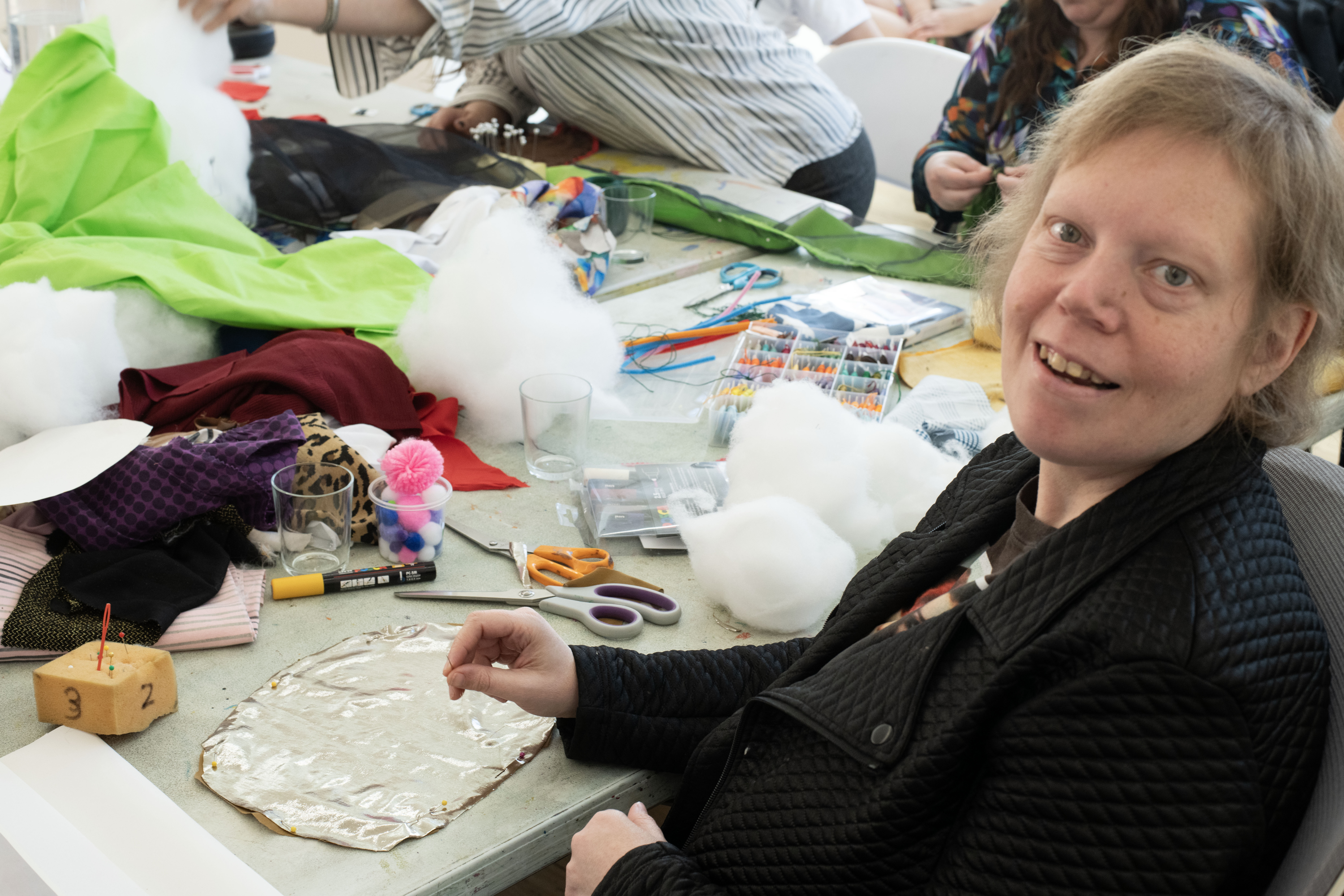 Bronwyn Hack at the Make Your Own Body Parts Workshop. Bronwyn is seated at the table and is looking back to the camera.